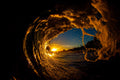 A wave curling around the setting sun