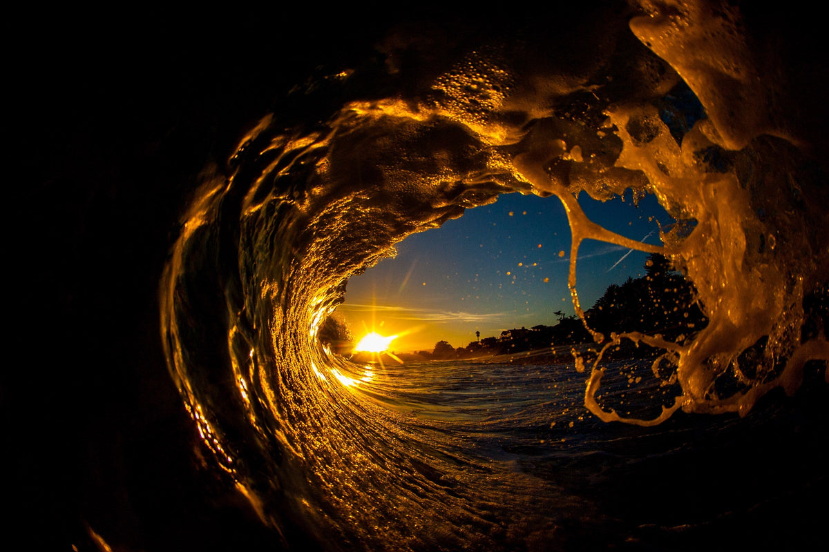 A wave curling around the setting sun