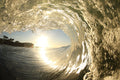 A wave tube with warm golden light shining through textured water