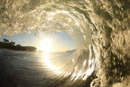 A wave tube with warm golden light shining through textured water