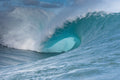 A massive blue wave curling over itself with no surfer in sight