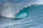 A massive blue wave curling over itself with no surfer in sight