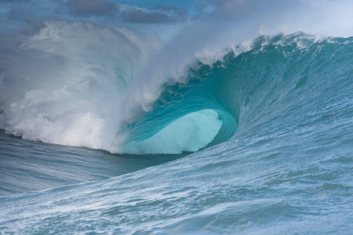 A massive blue wave curling over itself with no surfer in sight