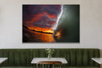 A tunnel of water lit by a fiery orange and red sunset sky shown large on the wall of a lived-in room