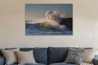 A wave exploding into a cloud of spray against a dark cliff shown large on the wall of a lived-in room
