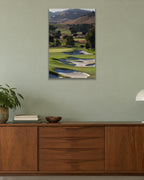 A golf course fairway winding through green hills with white sand bunkers shown large on the wall of a lived-in room
