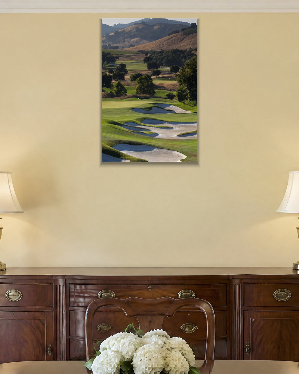 A golf course fairway winding through green hills with white sand bunkers shown large on the wall of a lived-in room
