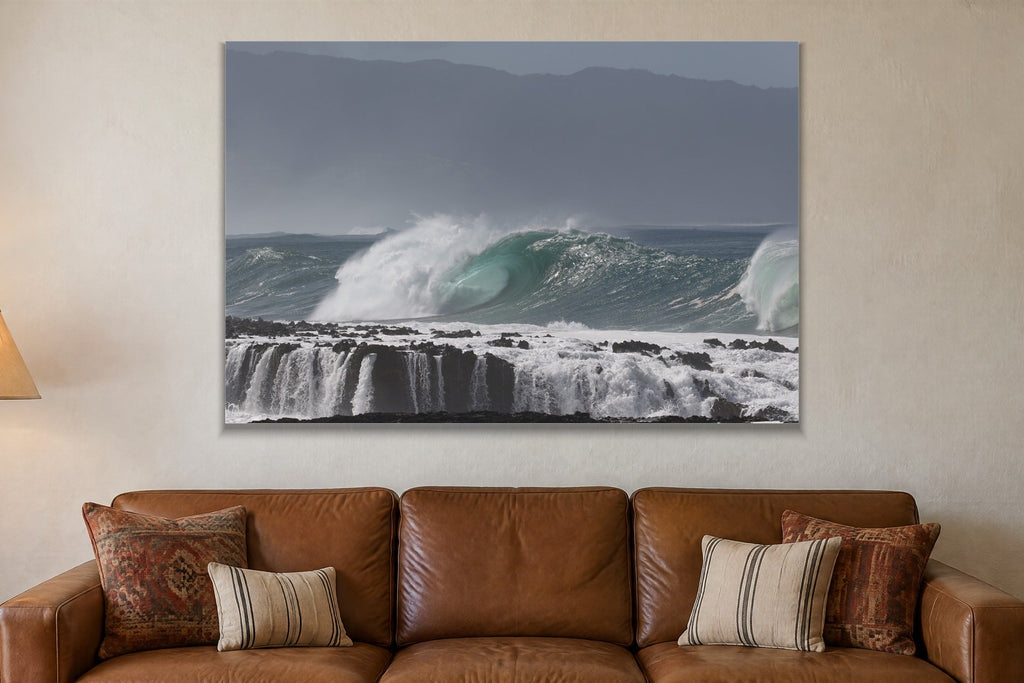 A wave peeling over a stepped reef ledge with white water pouring off it shown large on the wall of a lived-in room