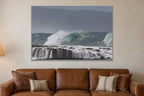 A wave peeling over a stepped reef ledge with white water pouring off it shown large on the wall of a lived-in room