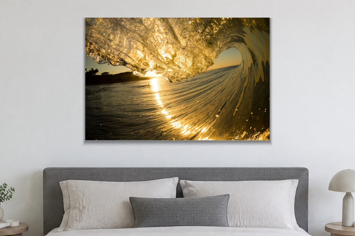 A wave curling in gold light with glittering water streaming down its face shown large on the wall of a lived-in room