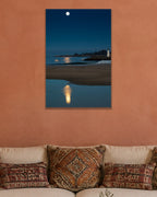 Moon Over the Lighthouse metal print hanging above furniture in a living space