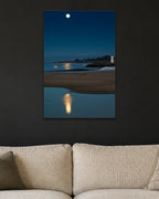Moon Over the Lighthouse metal print hanging above furniture in a living space