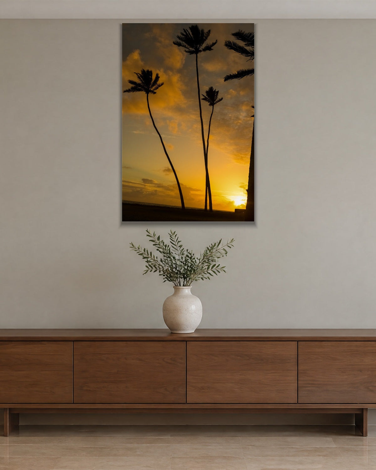 Silhouetted palm trees against a glowing orange and gold sunset shown large on the wall of a lived-in room