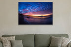 A fisheye view of a long pier under a sky of blue and pink clouds at sunset shown large on the wall of a lived-in room