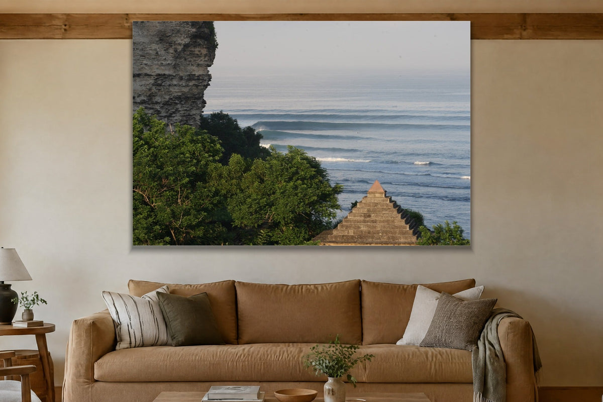 Long lines of swell marching past a rocky headland with a stone pyramid shown large on the wall of a lived-in room