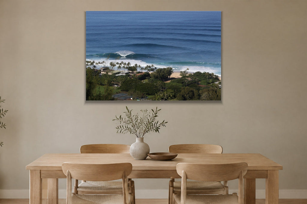 Long lines of swell approaching a palm-lined beach from above shown large on the wall of a lived-in room