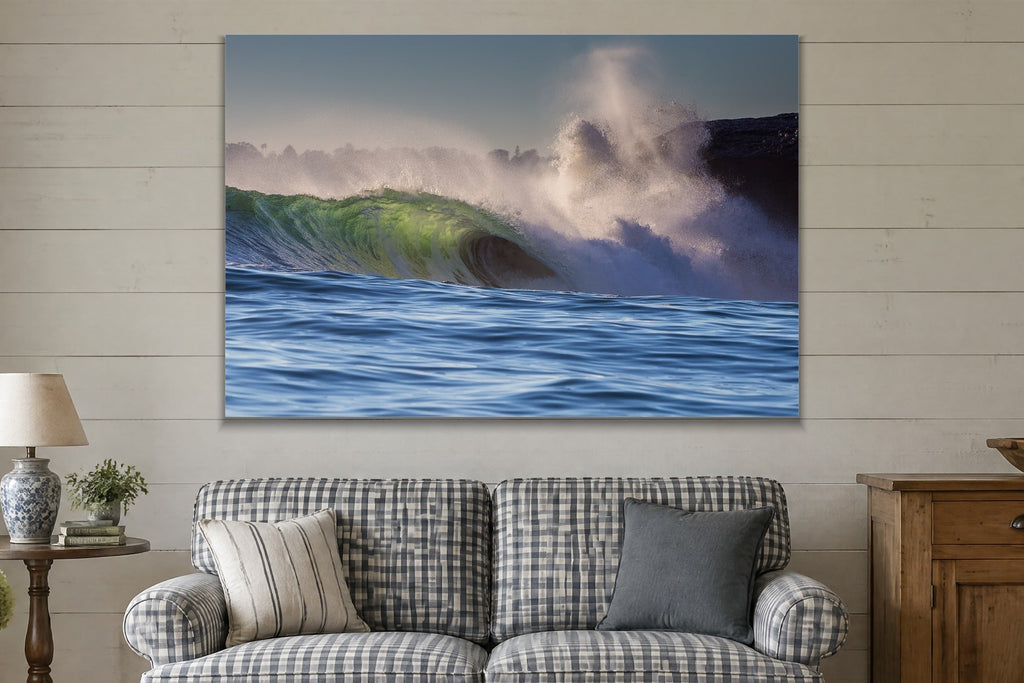 A heavy wave breaking next to a cliff with a plume of spray shown large on the wall of a lived-in room