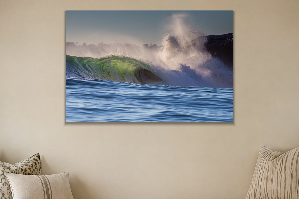 A heavy wave breaking next to a cliff with a plume of spray shown large on the wall of a lived-in room