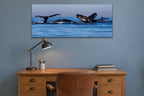 Whale Family metal print hanging above furniture in a living space